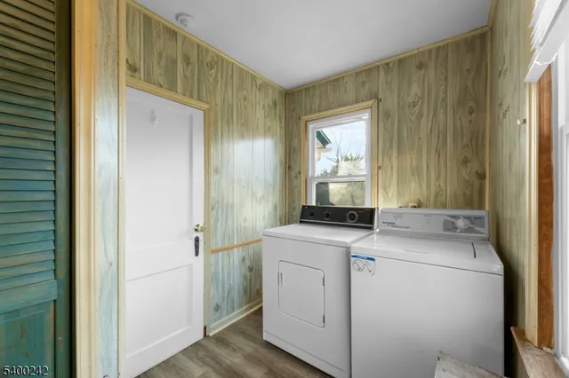 a view of washer and dryer with bathroom in the background