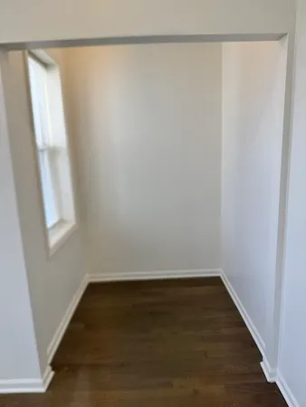 a view of a small space with wooden floor and a window
