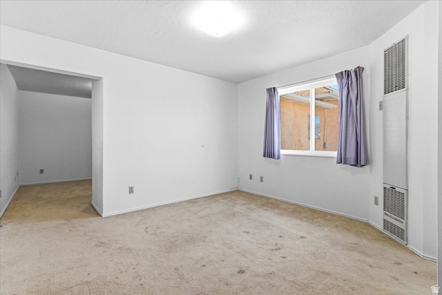 217 East 400 South Spring City, UT 84662 - Photo 31 of 71 Unfurnished room featuring a heating unit, light carpet, and a textured ceiling