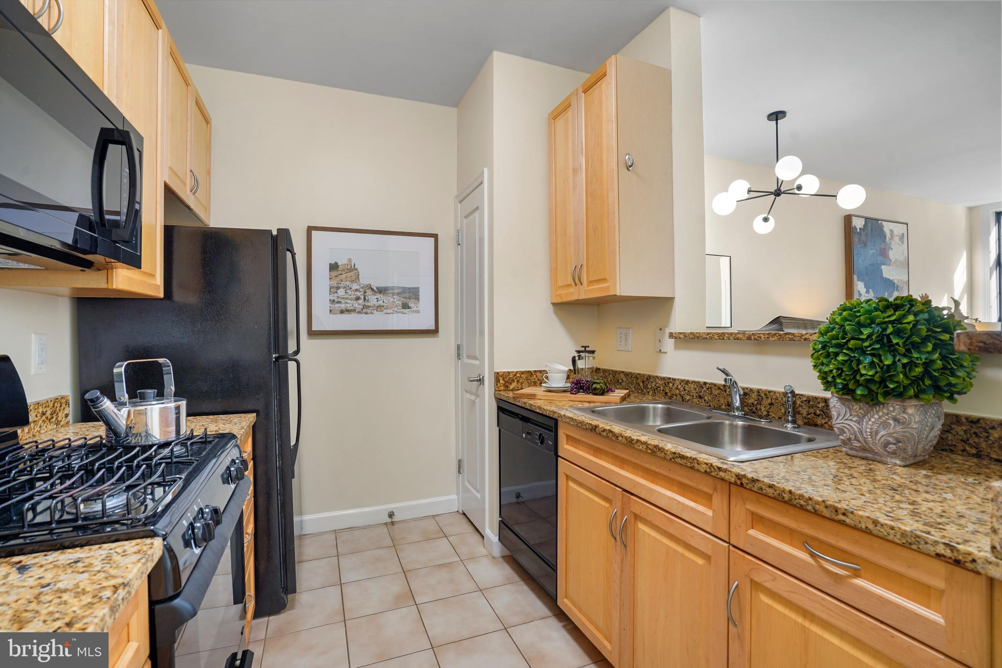 1111 25th Street Northwest, Unit 403 Washington, DC 20037 - Photo 5 of 24 a kitchen with stainless steel appliances granite countertop a stove a sink and a microwave