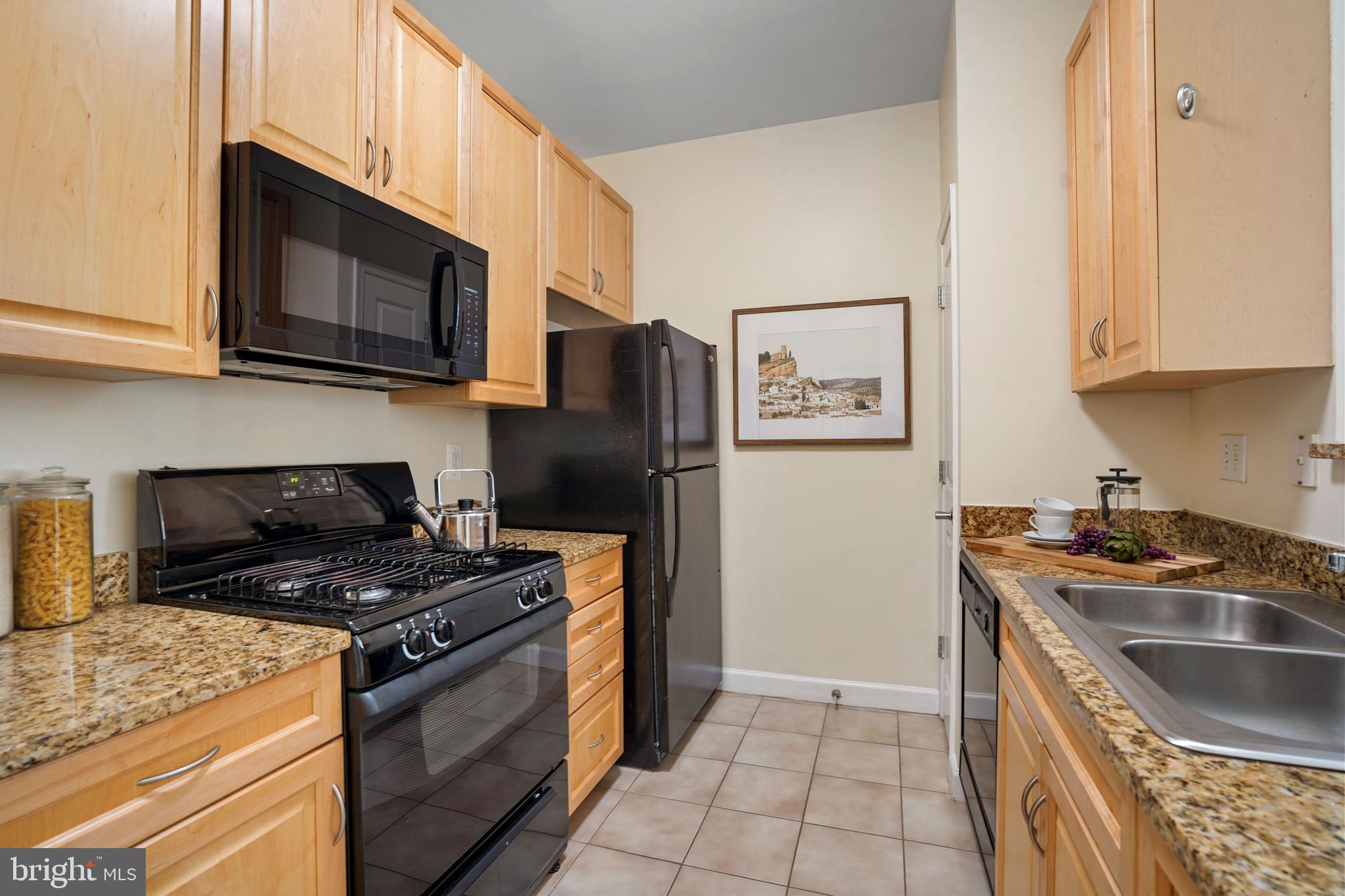 1111 25th Street Northwest, Unit 403 Washington, DC 20037 - Photo 10 of 24 a kitchen with stainless steel appliances granite countertop a stove a refrigerator and a sink