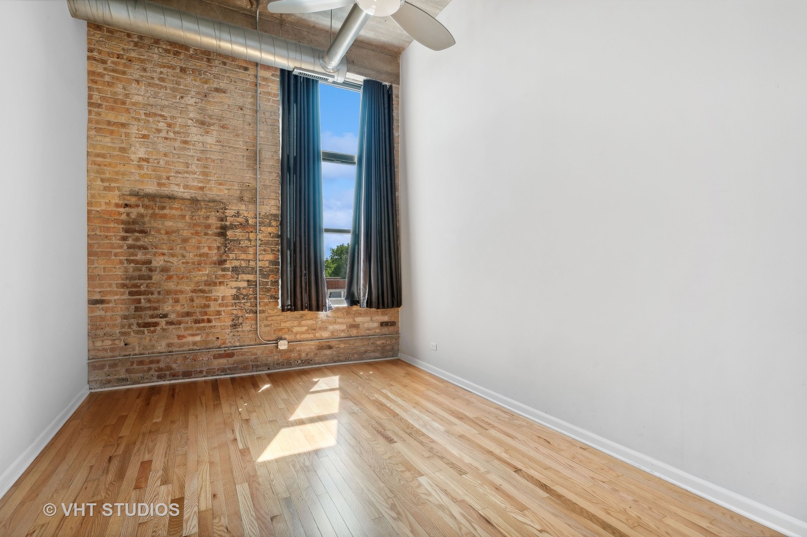 1820 North Spaulding Avenue, Unit 403 Chicago, IL 60647 - Photo 9 of 17 a view of an empty room with wooden floor and a window