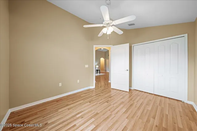 a view of empty room with wooden floor