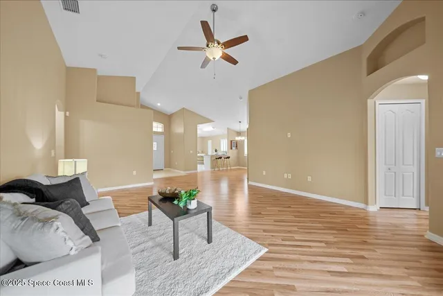 a living room with furniture and a ceiling fan