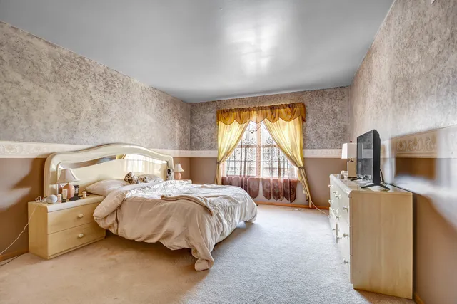 a bedroom with bed and a large window