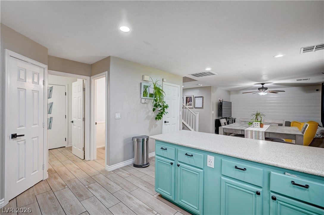 197 Kings Canyon Court Henderson, NV 89012 - Photo 12 of 39 Kitchen with ceiling fan, light countertops, light wood-style floors, recessed lighting, and blue cabinetry