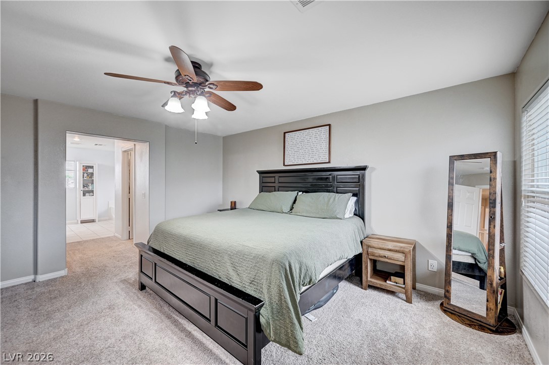 197 Kings Canyon Court Henderson, NV 89012 - Photo 23 of 39 Bedroom featuring light carpet and a ceiling fan