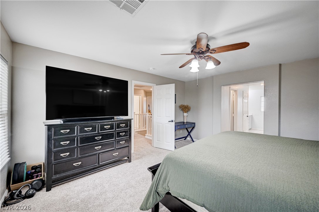 197 Kings Canyon Court Henderson, NV 89012 - Photo 24 of 39 Bedroom featuring light carpet, ceiling fan, ensuite bathroom, and multiple windows