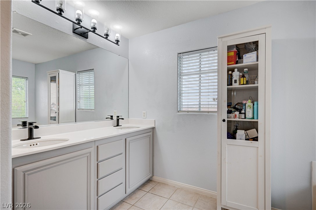 197 Kings Canyon Court Henderson, NV 89012 - Photo 25 of 39 Primary bathroom with double vanity and tile patterned flooring