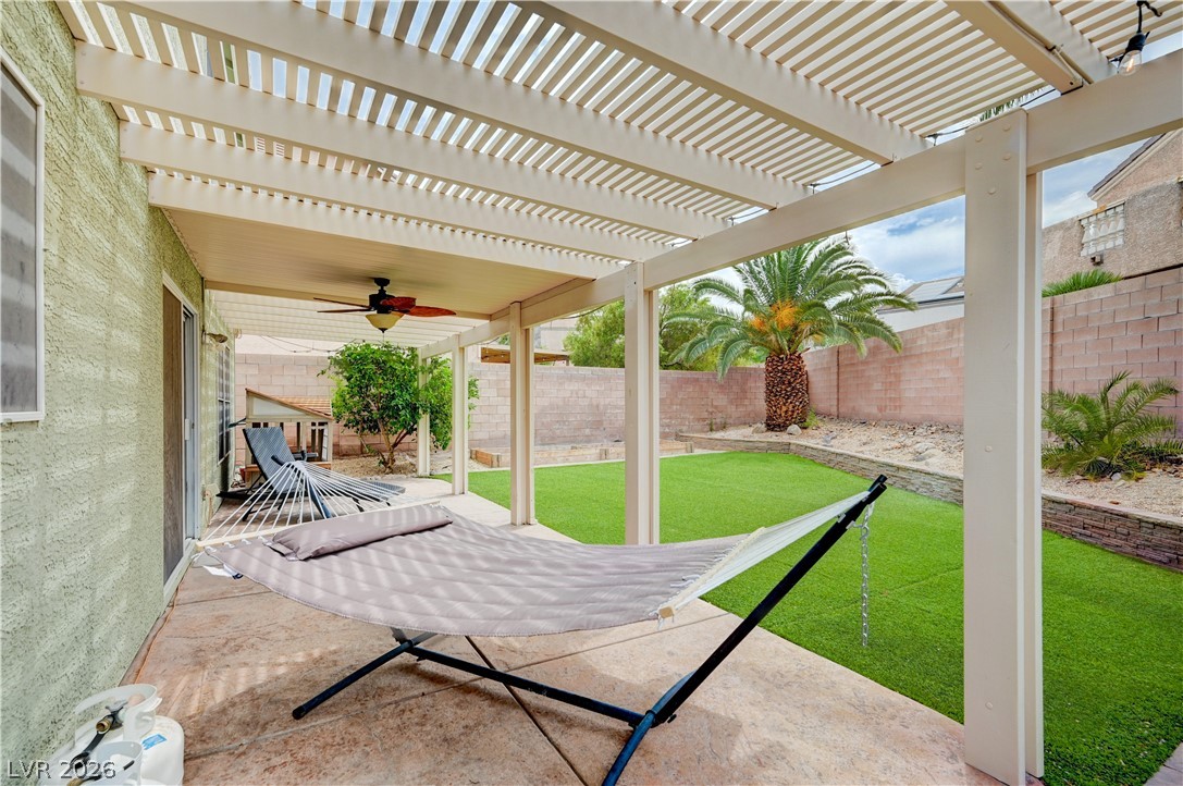 197 Kings Canyon Court Henderson, NV 89012 - Photo 33 of 39 Fenced backyard with a ceiling fan, a patio area, and a pergola
