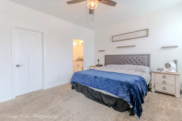 a spacious bedroom with a bed and a chandelier