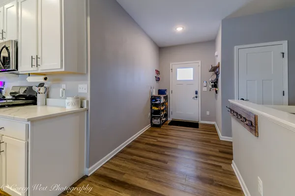 a view of a kitchen with wooden floor and electronic appliances