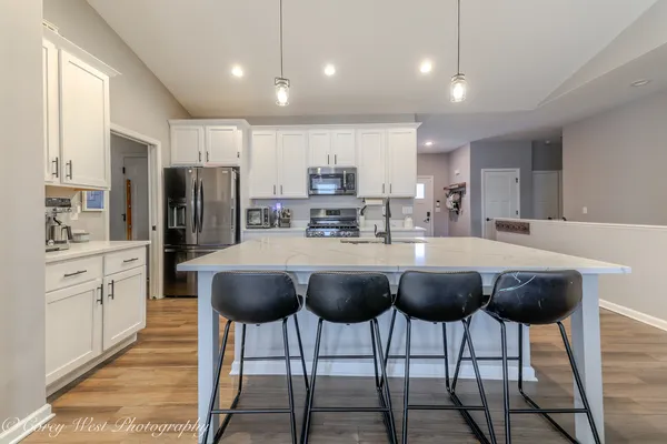 a kitchen with stainless steel appliances granite countertop a refrigerator and a stove top oven