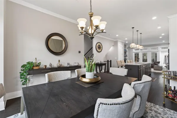 a living room with a couch a dining table and a chandelier