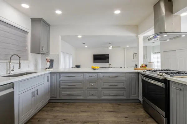 a kitchen with stainless steel appliances kitchen island granite countertop a sink and cabinets