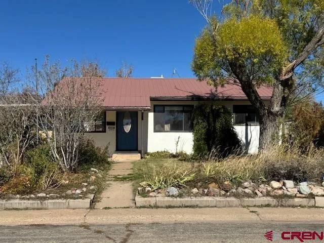 a front view of a house with a yard and trees