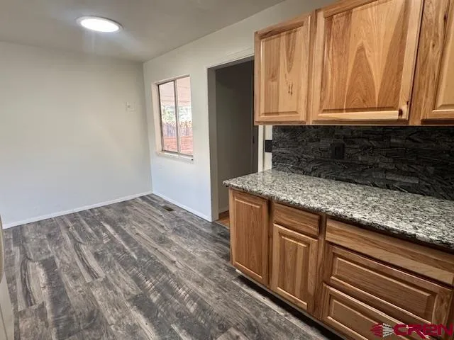 a kitchen with granite countertop wooden cabinets and sink