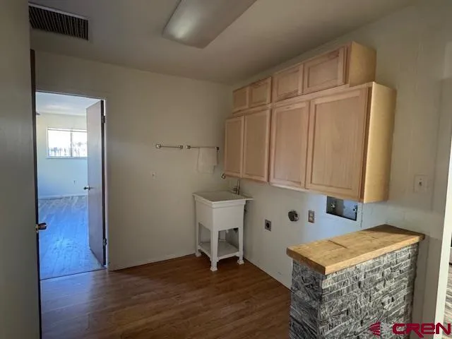 a view of an empty room with wooden floor and a cabinet
