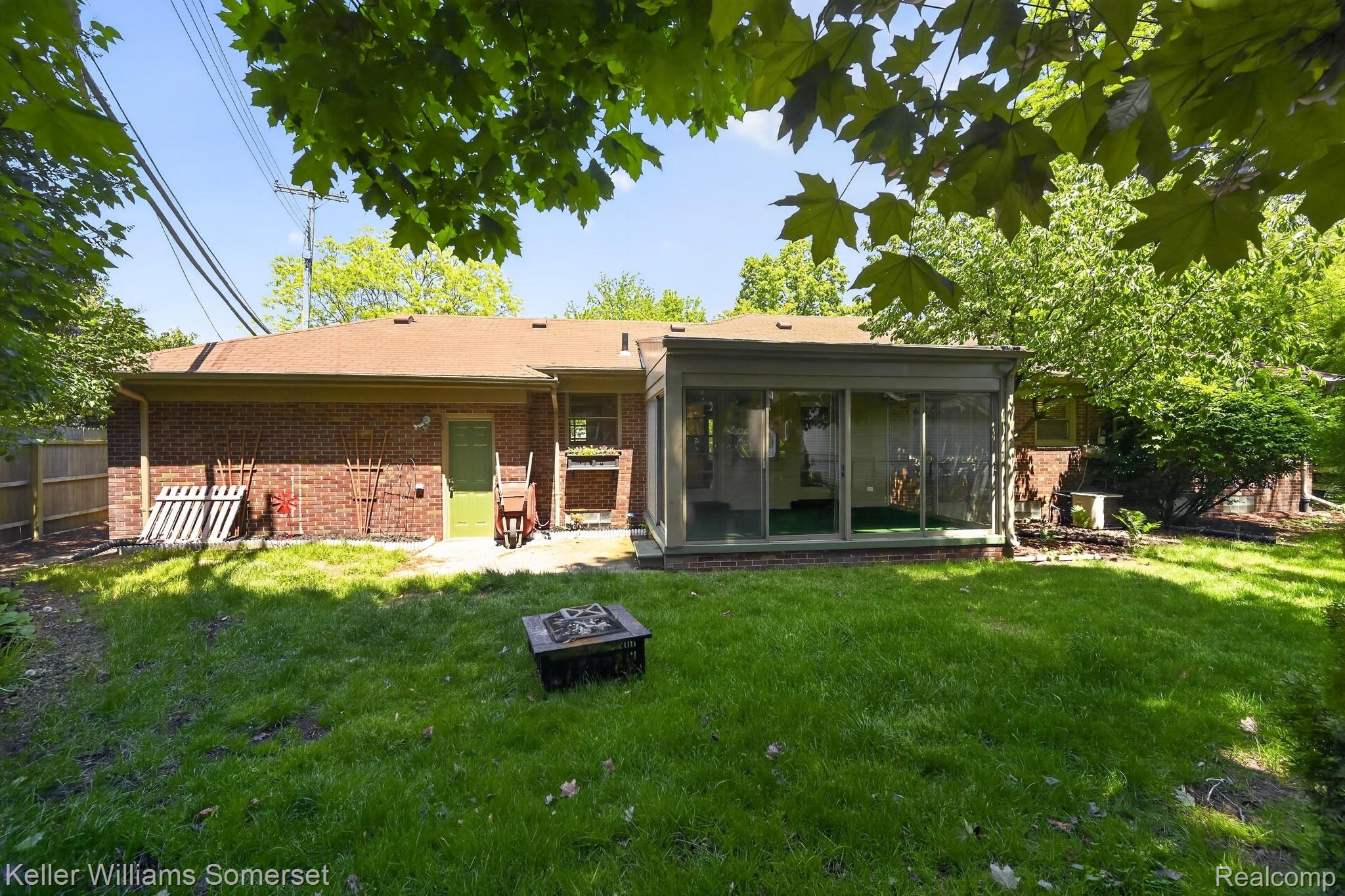 1681 Oxford Road Grosse Pointe, MI 48236 - Photo 23 of 25 Back of property with an outdoor fire pit, a sunroom, and brick siding