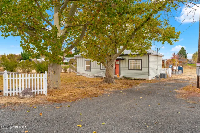 a front view of a house with a tree