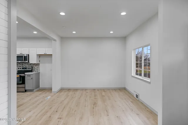 an empty room with wooden floor and a window