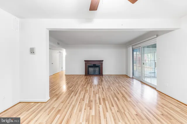 a view of empty room with wooden floor and fireplace