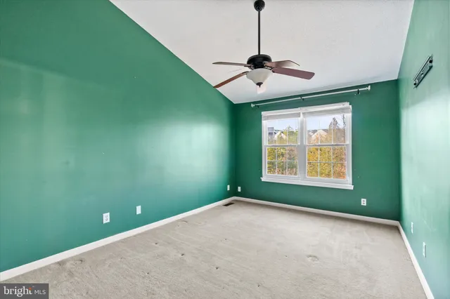 a view of an empty room with a window and a fan