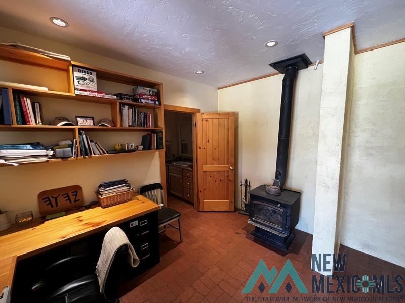 150 Forrest Service Road 124 Road Chamisal, NM 87521 - Photo 15 of 42 Office featuring brick patterned floors, a wood stove, a textured ceiling, and recessed lighting