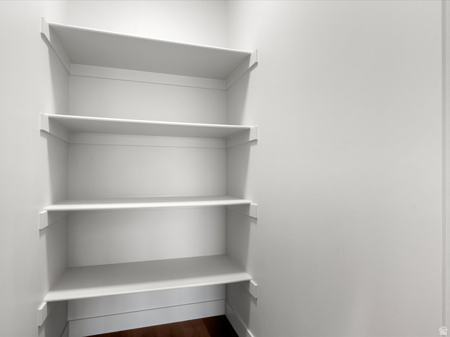 1159 North Broad Hollow Road Garden City, UT 84028 - Photo 54 of 55 Built-in white shelving system with five levels of storage, integrated baseboard trim, and dark wood-finish flooring