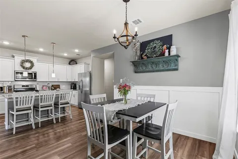 a view of a dining room with furniture wooden floor and chandelier