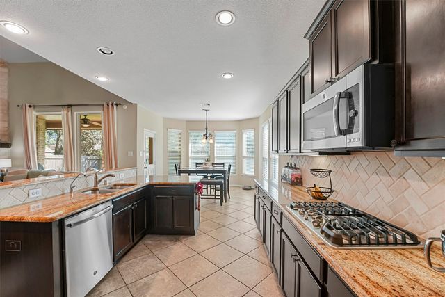 a kitchen with lots of counter top space and stainless steel appliances