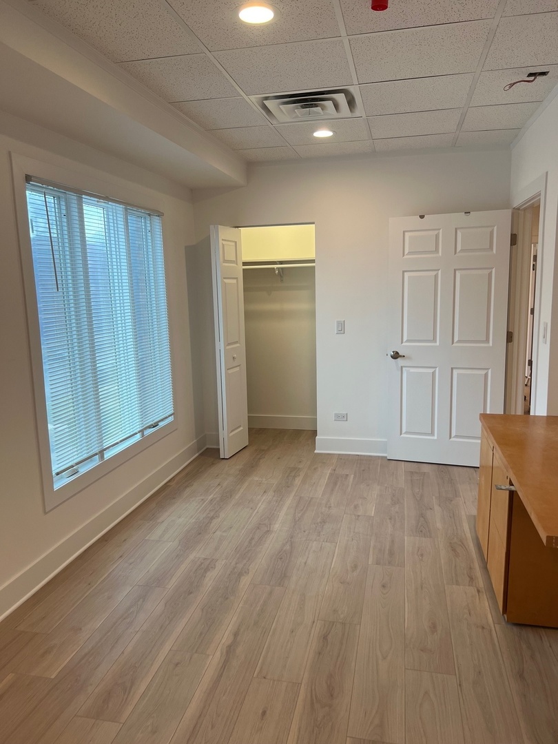 1930 Sherman Avenue, Unit 1N Evanston, IL 60201 - Photo 12 of 20 an empty room with wooden floor cabinet and windows