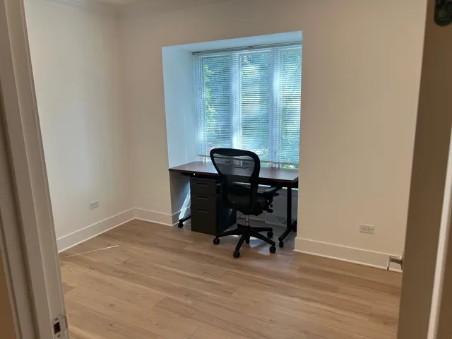 a view of a workspace with furniture and a window