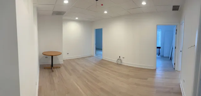an empty room with wooden floor and glass door