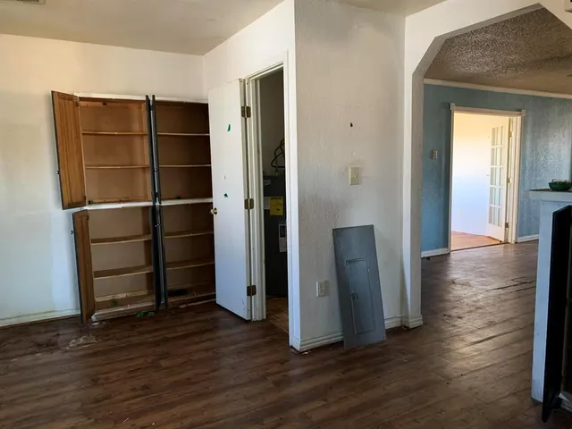 an empty room with wooden floor and a cabinet