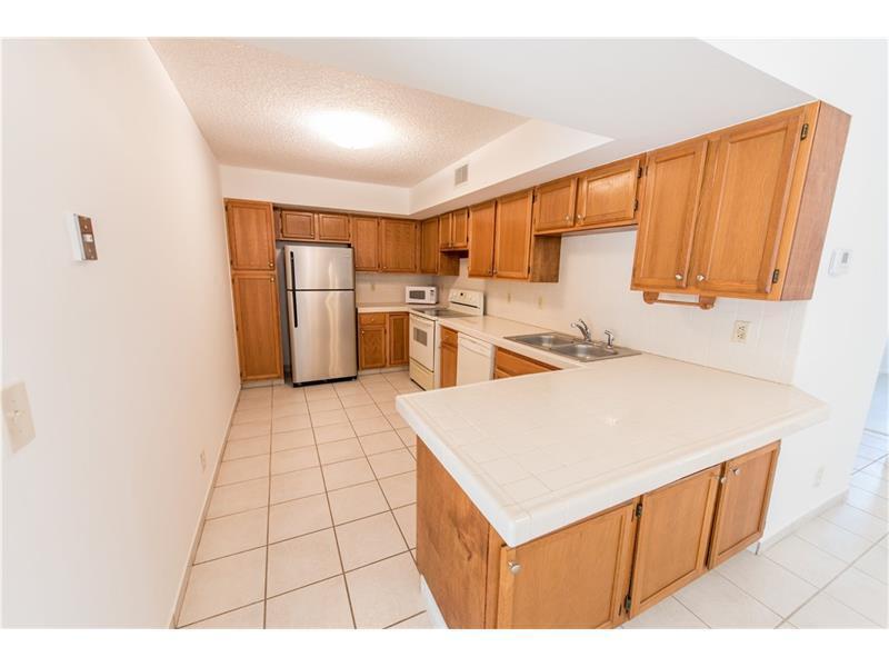 3150 Leewood Terrace, Unit L224 Boca Raton, FL 33431 - Photo 2 of 14 a open kitchen with a sink a refrigerator and a stove
