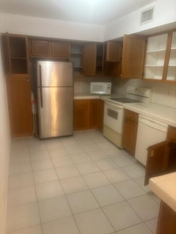 3150 Leewood Terrace, Unit L224 Boca Raton, FL 33431 - Photo 3 of 14 a kitchen with stainless steel appliances a refrigerator and a stove top oven
