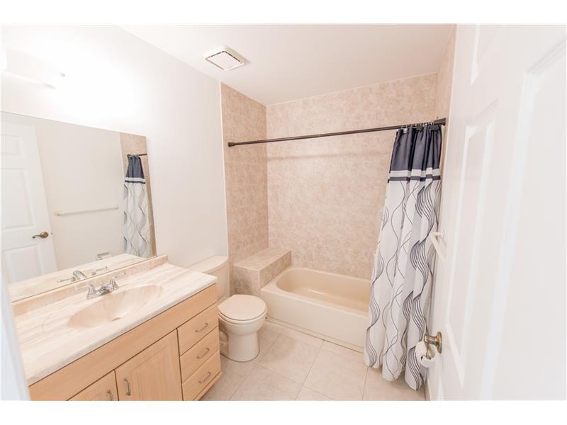 3150 Leewood Terrace, Unit L224 Boca Raton, FL 33431 - Photo 4 of 14 a bathroom with a sink toilet a mirror and shower
