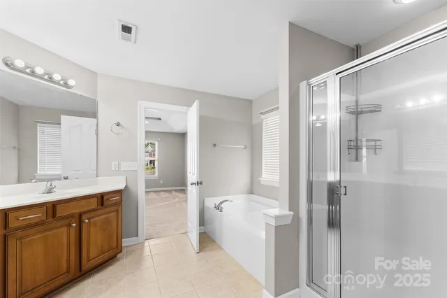 a spacious bathroom with a shower sink and mirror