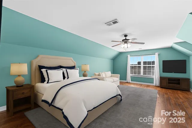 a spacious bedroom with a bed and a flat screen tv