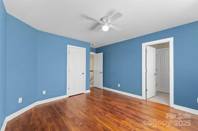 a view of a livingroom with a ceiling fan and wooden floor