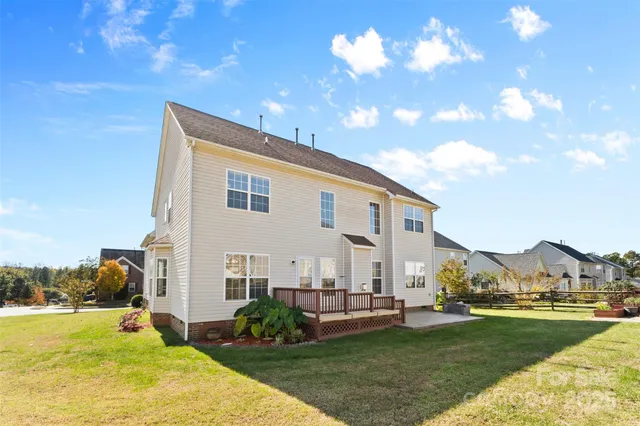 a view of a house with a big yard and large trees