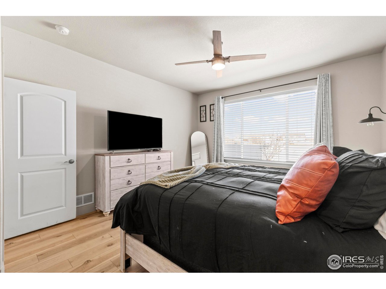 1216 Muskox Street Severance, CO 80550 - Photo 17 of 37 a bedroom with a bed window and a flat screen tv