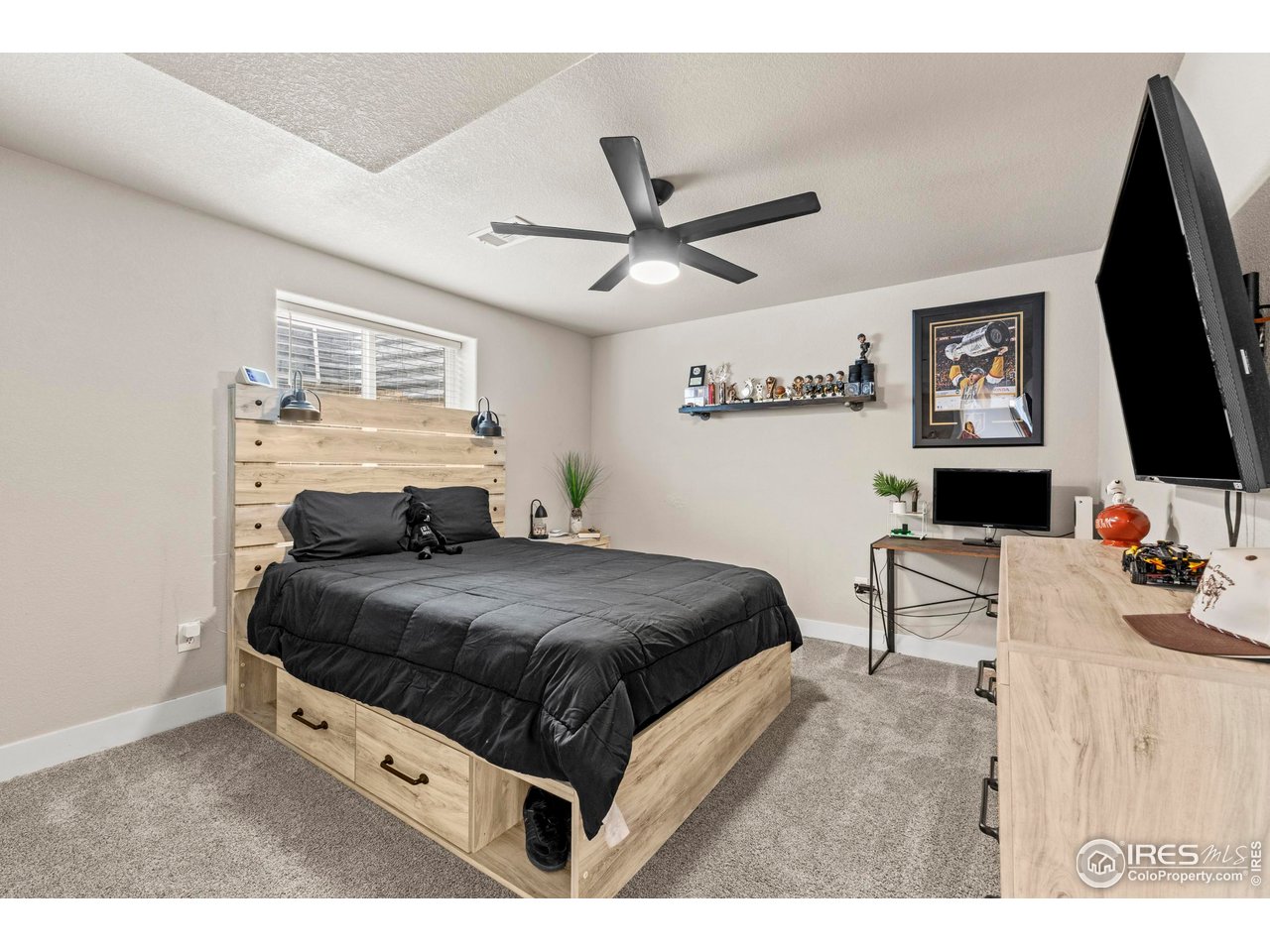 1216 Muskox Street Severance, CO 80550 - Photo 32 of 37 a bedroom with a bed and a flat screen tv