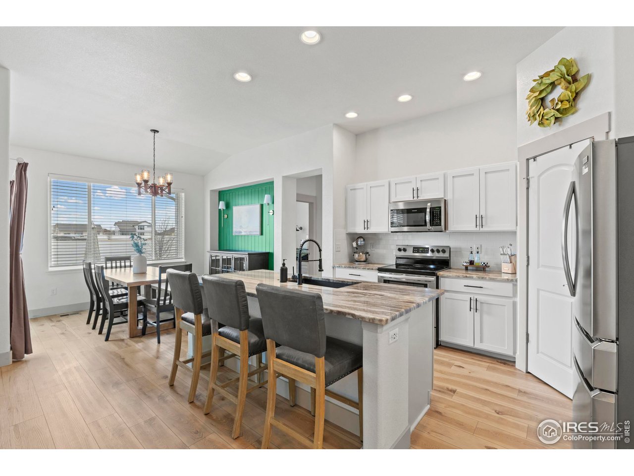 1216 Muskox Street Severance, CO 80550 - Photo 4 of 37 a kitchen with a dining table chairs stainless steel appliances and cabinets