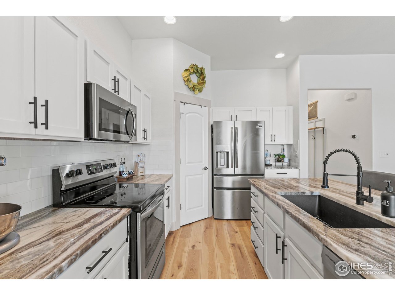 1216 Muskox Street Severance, CO 80550 - Photo 6 of 37 a kitchen with a refrigerator a sink a stove and cabinets