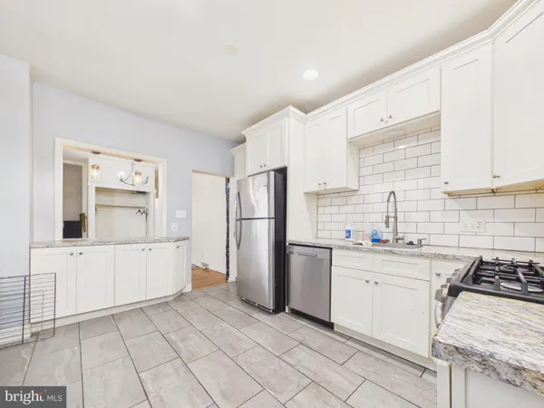 a kitchen with white cabinets and appliances