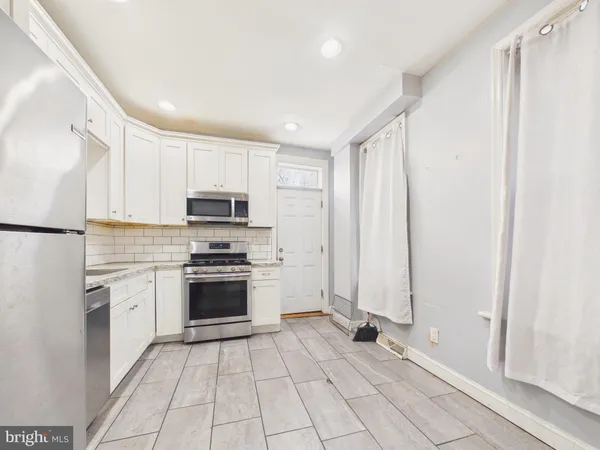 a kitchen with stainless steel appliances granite countertop a refrigerator and a stove top oven