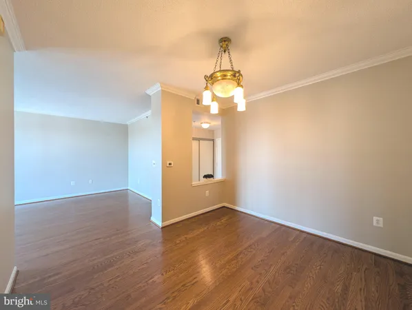 a view of a hallway with wooden floor and chandelier