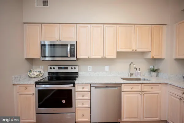a kitchen with white cabinets and stainless steel appliances